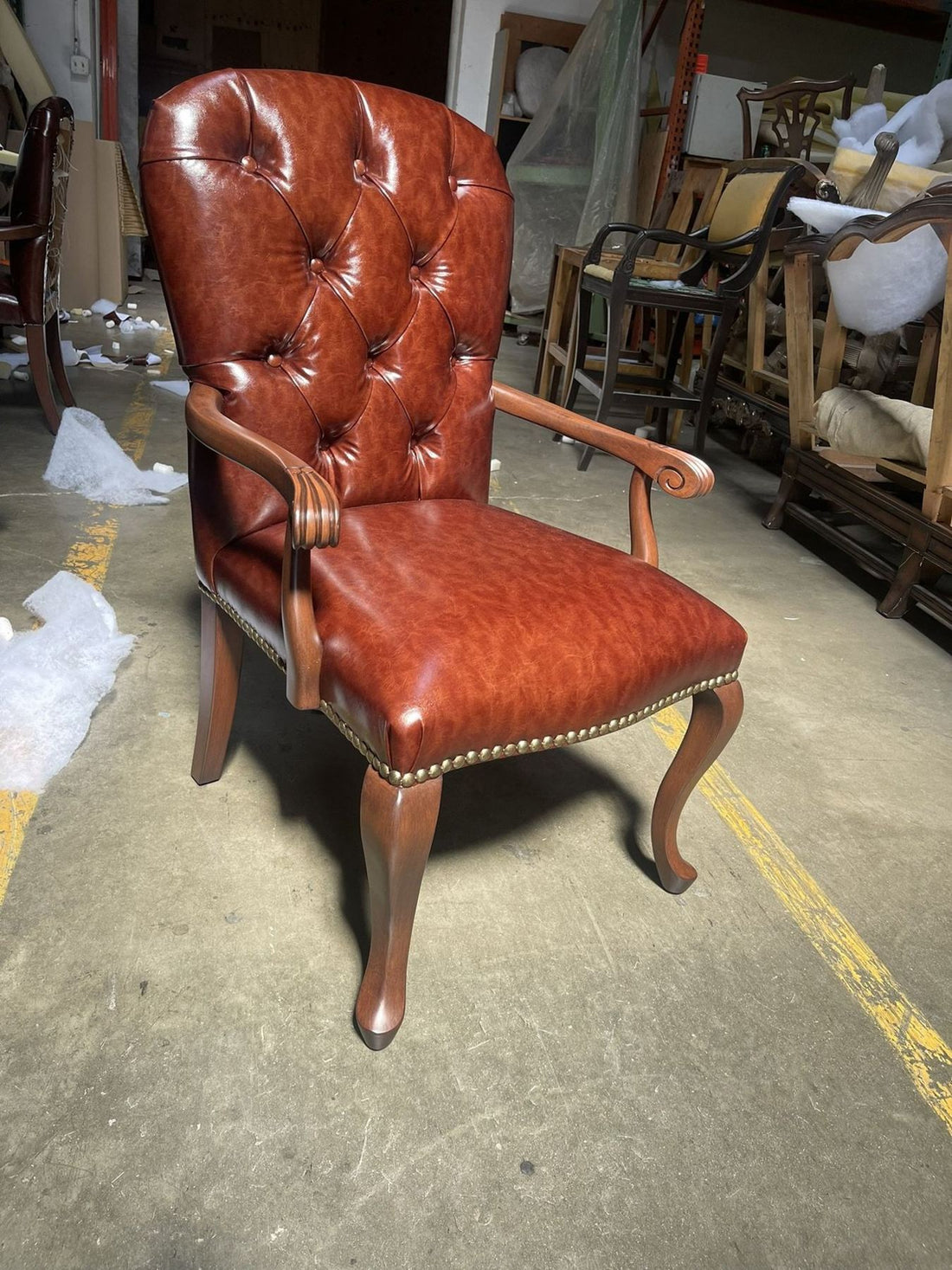 Button-tufted leather armchairs with nailhead trim