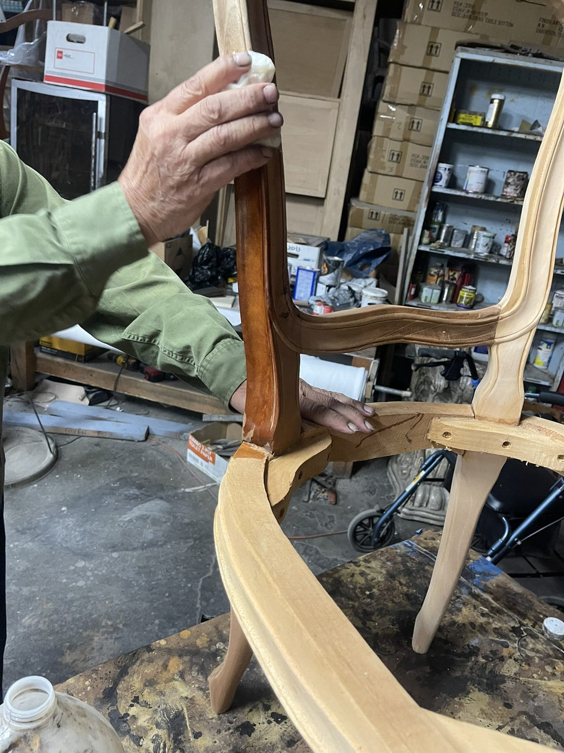 Craftsman fitting a hand-shaped wooden chair frame in the Sigla workshop