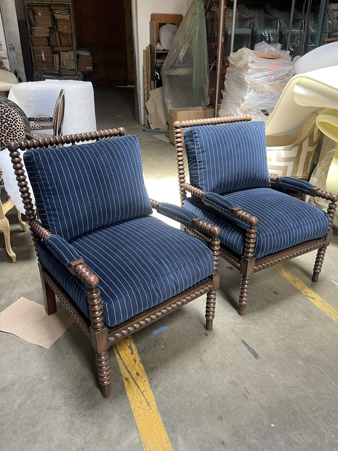 Pair of spindle lounge chairs upholstered in navy stripe