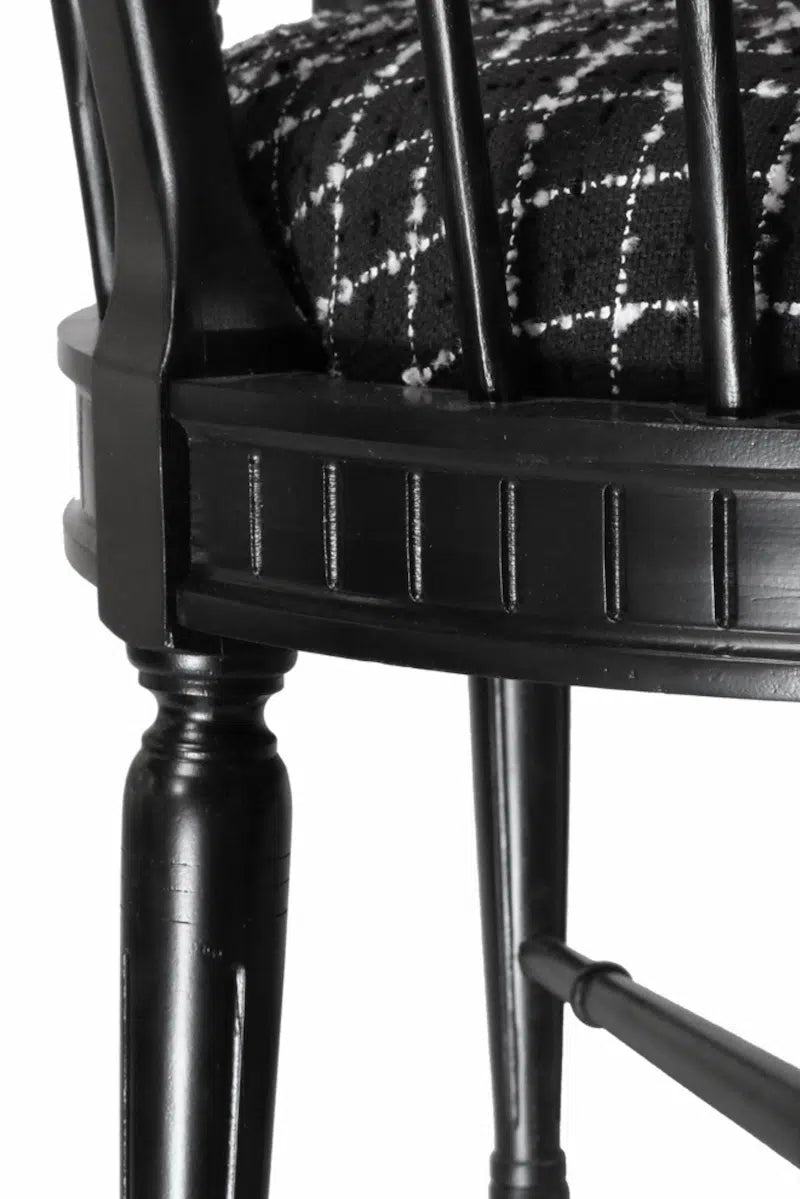 Black lounge chair with plaid cushion on a white background